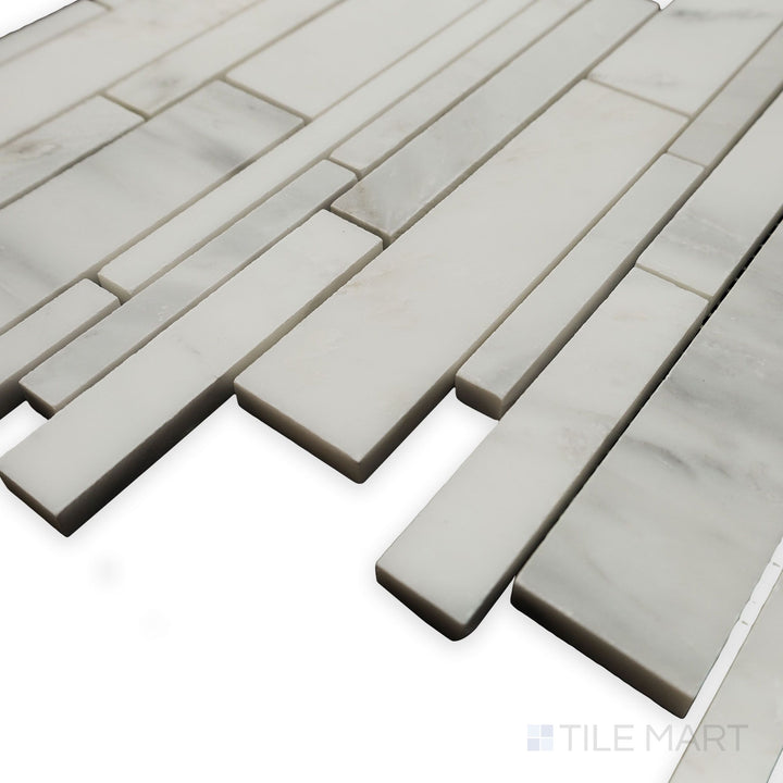 From a sleek side angle, the Oriental White Marble Linear honed mosaic emphasizes its continuous flow and subtle matte finish for a minimalist appeal.