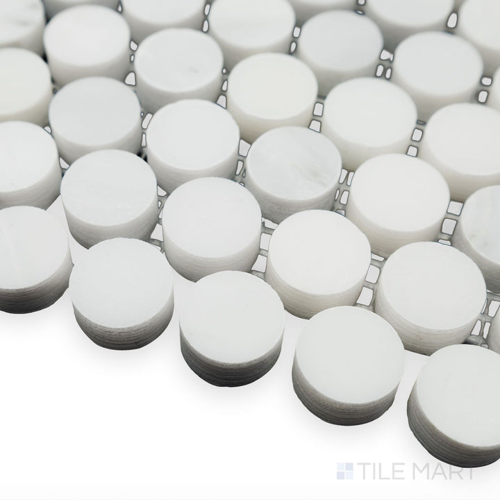 A timeless penny round pattern is captured in this soft corner angle of Oriental White Marble 3/4" Penny Round honed mosaic, where its matte texture complements classic design.