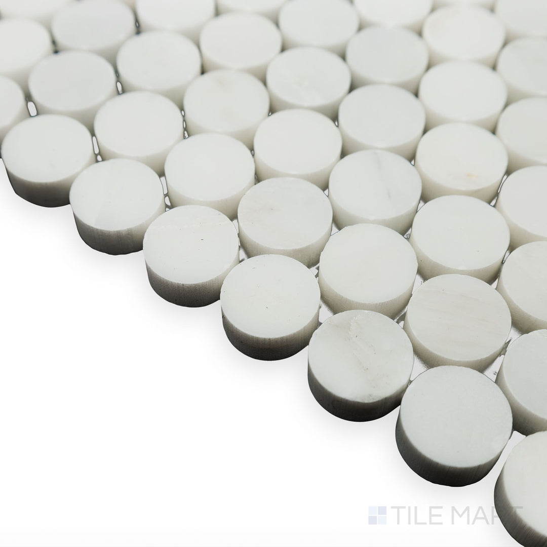 Light enhances the smooth curves in this corner shot of Oriental White Marble 3/4" Penny Round polished mosaic, emphasizing its glossy and elegant finish.