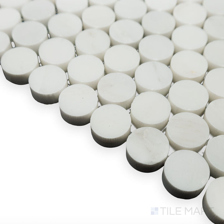 Light enhances the smooth curves in this corner shot of Oriental White Marble 3/4" Penny Round polished mosaic, emphasizing its glossy and elegant finish.