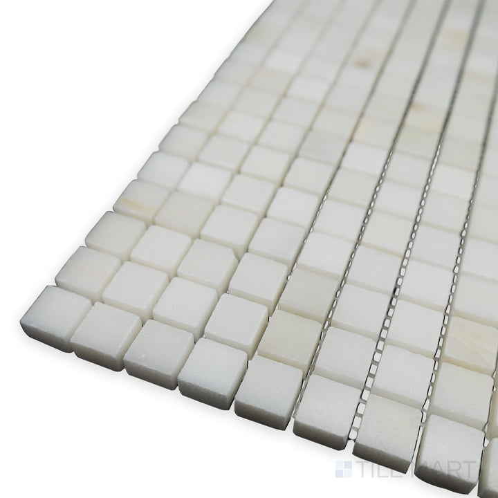 With a smooth and polished surface, this angled corner view of Oriental White Marble 5/8" Square polished mosaic highlights its small-format elegance.