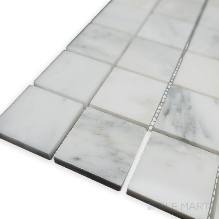 A luminous and polished surface elevates the refined grid pattern in this corner shot of Oriental White Marble 2" Square polished mosaic, creating a bright and sophisticated look.