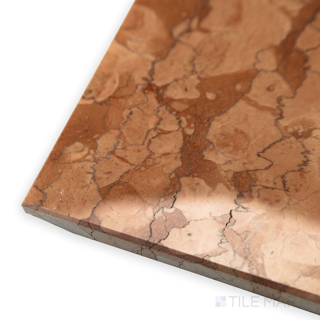 A polished surface gleams in this angled corner shot of Rosa Verona Marble 12x12 polished tile, highlighting its warm reddish hues and natural veining.