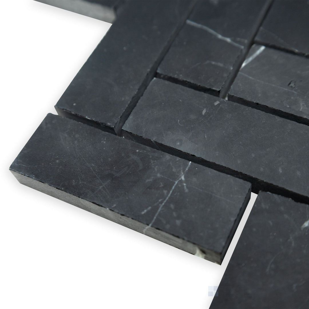 A refined herringbone arrangement is displayed in this angled corner perspective of Negro Marquina Marble 1x3 herringbone honed mosaic, where its honed surface adds a subtle charm.