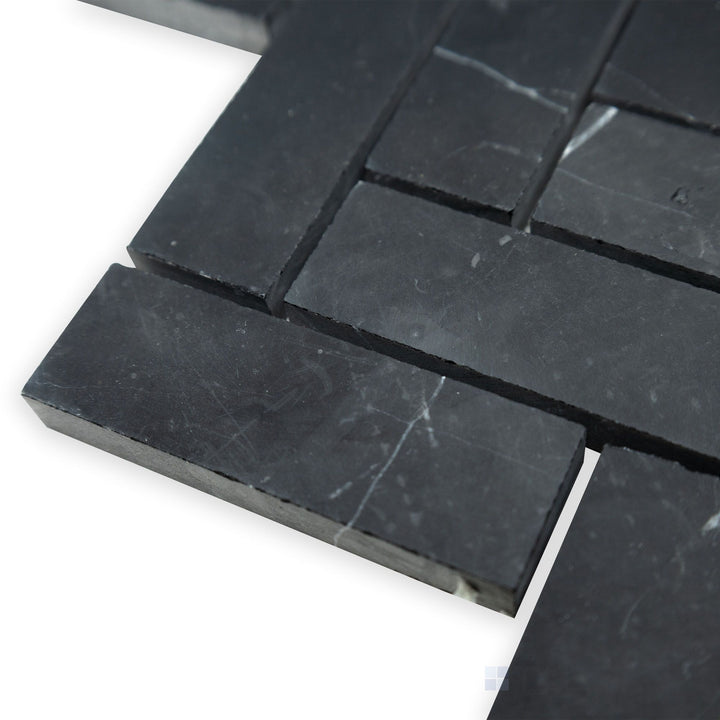 A refined herringbone arrangement is displayed in this angled corner perspective of Negro Marquina Marble 1x3 herringbone honed mosaic, where its honed surface adds a subtle charm.