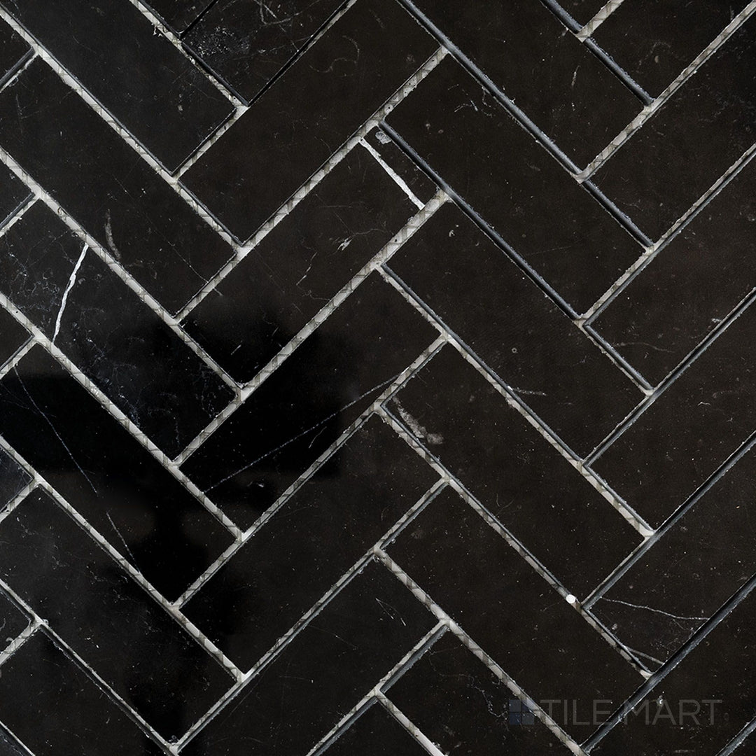 Top-view photo of Negro Marquina Marble 1x3 herringbone polished mosaic, featuring a sleek polished finish that highlights the dramatic black and white contrast.