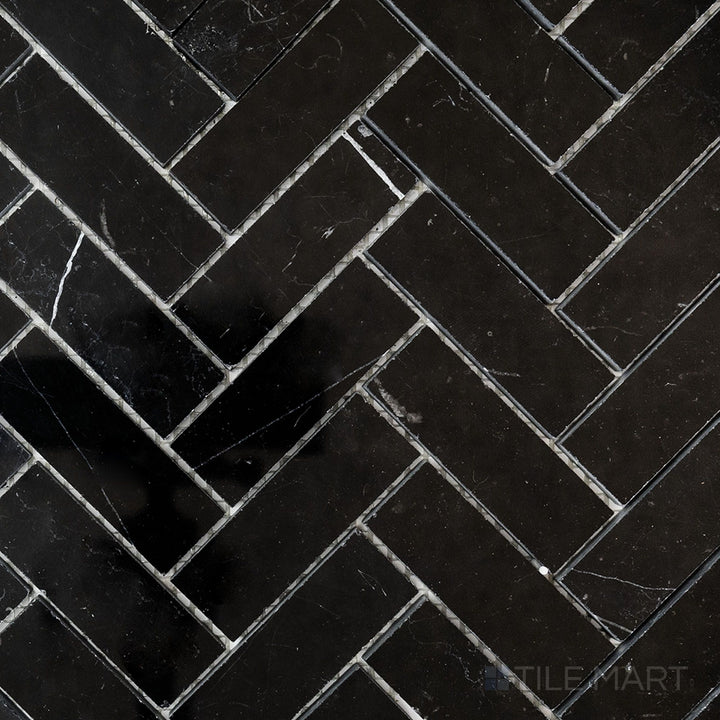 Top-view photo of Negro Marquina Marble 1x3 herringbone polished mosaic, featuring a sleek polished finish that highlights the dramatic black and white contrast.