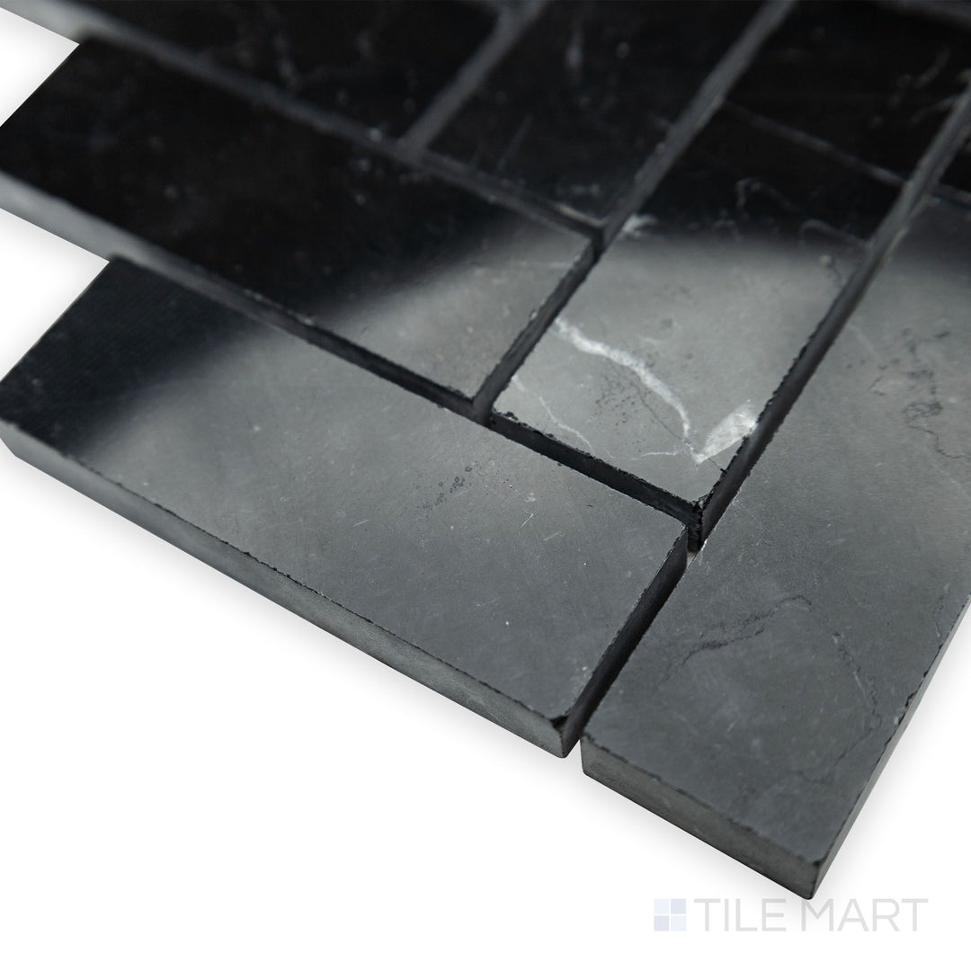 With a striking polished sheen, the flowing herringbone design of Negro Marquina Marble 1x3 herringbone polished mosaic is enhanced in this bright corner shot.