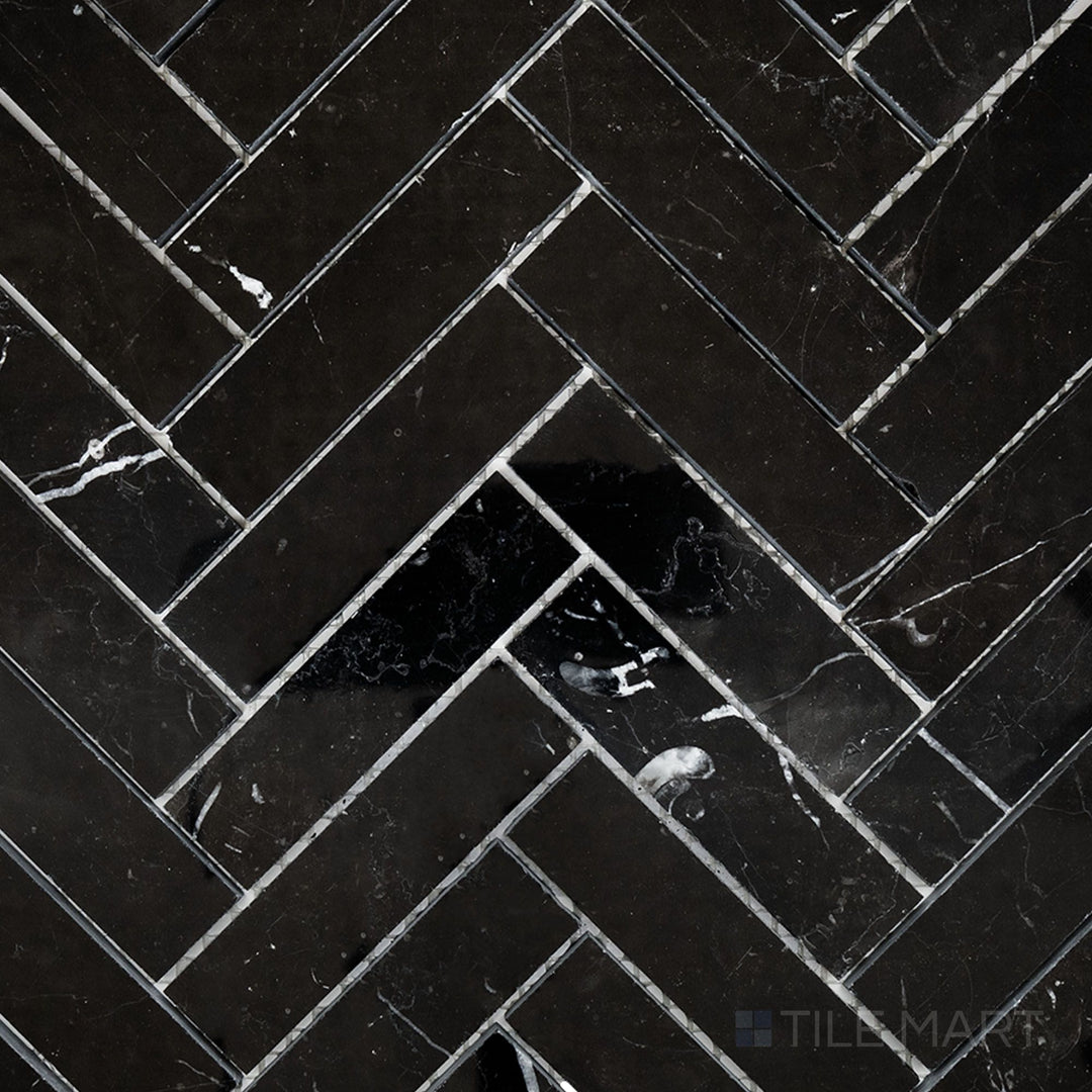 Flat-lay shot of Negro Marquina Marble 1x4 herringbone polished mosaic, offering a glossy herringbone layout that enhances its bold veining.