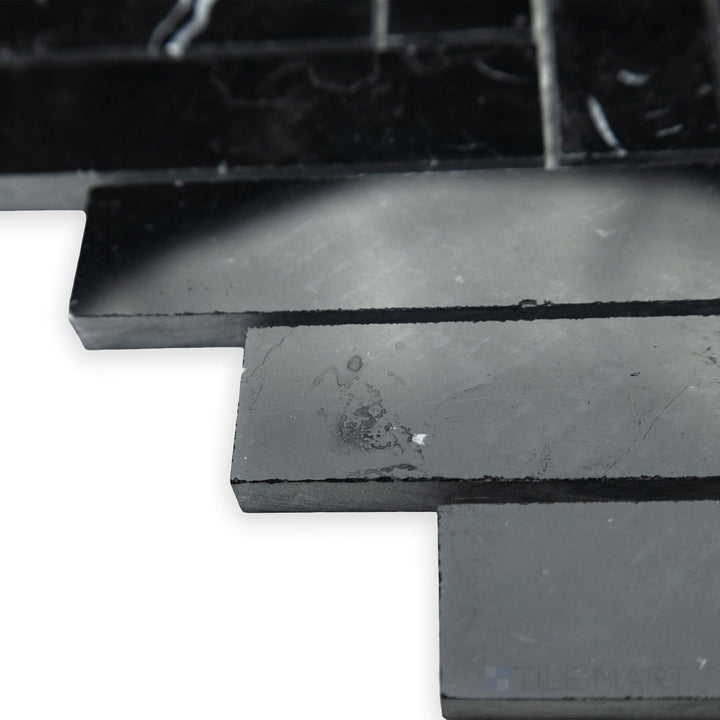 A polished elegance emerges in this soft corner perspective of Negro Marquina Marble 1x4 herringbone polished mosaic, capturing its intricate layout and smooth finish.