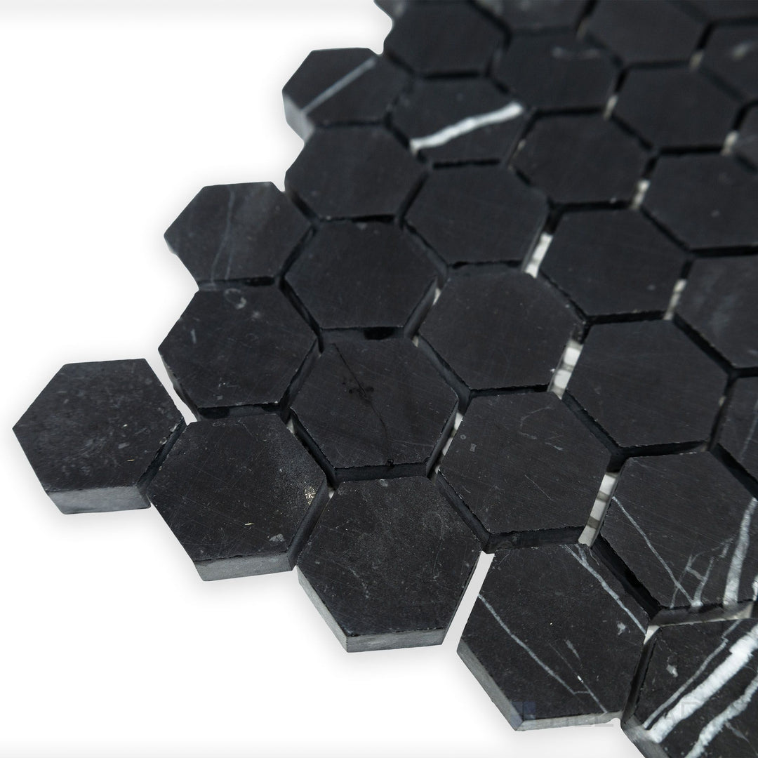 A structured hexagonal pattern stands out in this angled corner shot of Negro Marquina Marble 1" hexagon honed mosaic, where its honed surface complements the bold geometric design.