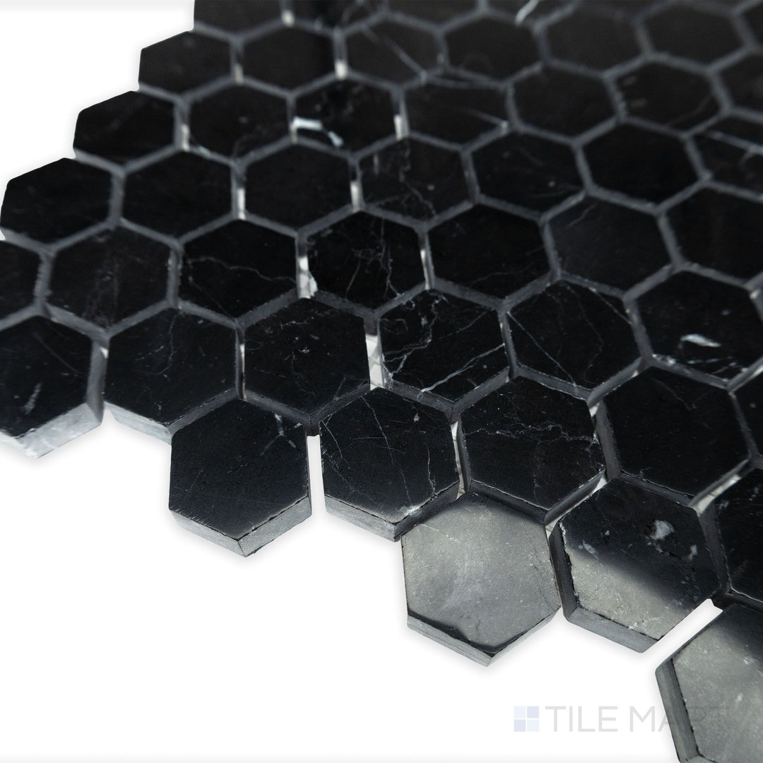 A polished hexagonal layout glows in this softly lit corner shot of Negro Marquina Marble 1" hexagon polished mosaic, enhancing the deep contrast of black marble with white veining.