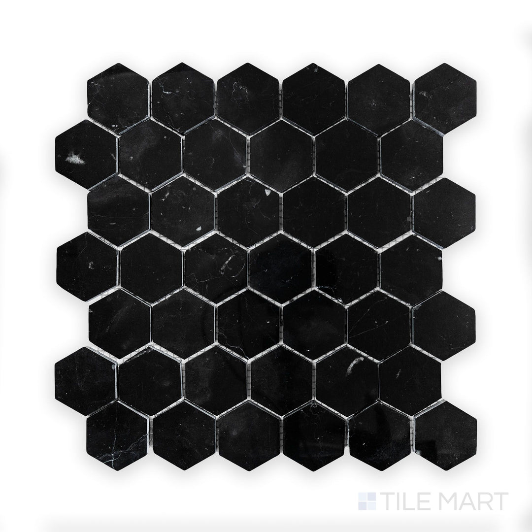 A close-up of Negro Marquina Marble 2" Hexagon Polished Mosaic, featuring bold white veining on a high-gloss black surface.