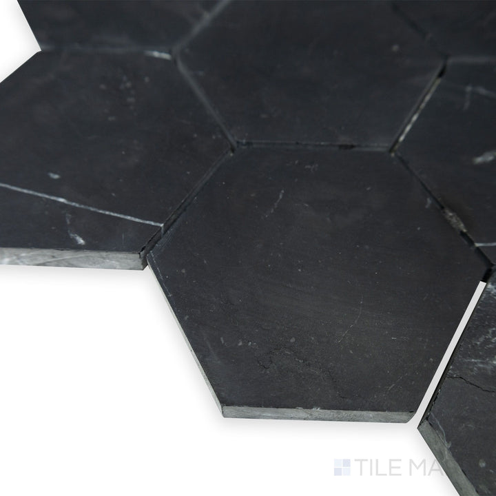 A refined hexagonal pattern emerges in this corner perspective of Negro Marquina Marble 3" hexagon honed mosaic, where the soft matte finish complements its bold geometric design.