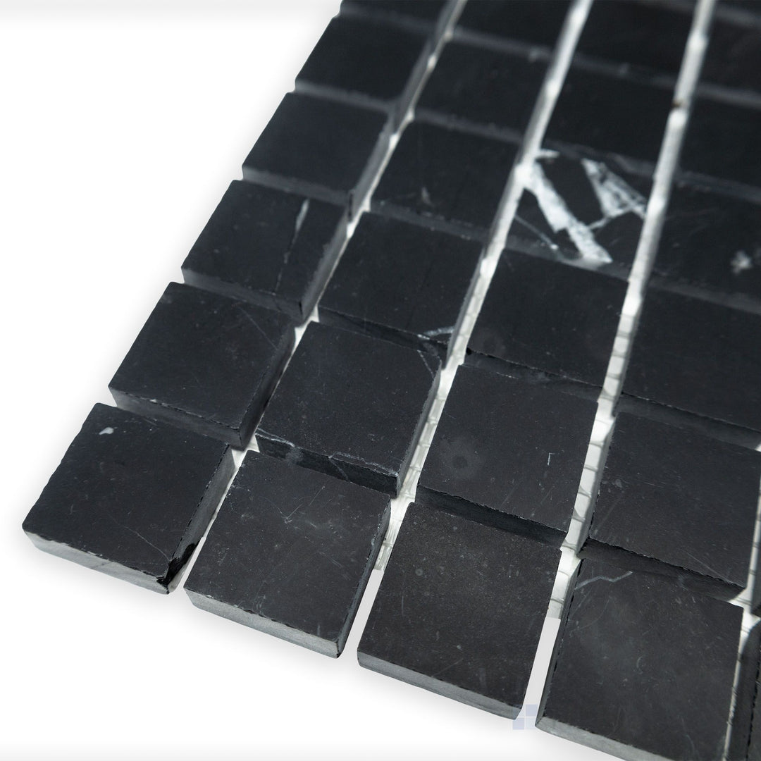 From a structured side view, the Negro Marquina Marble 1" square honed mosaic showcases its seamless grid design, where its matte finish enhances the natural elegance of the stone.