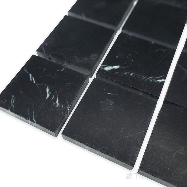 A modern square arrangement comes to life in this corner shot of Negro Marquina Marble 2" square honed mosaic, where the smooth matte surface adds a contemporary touch.