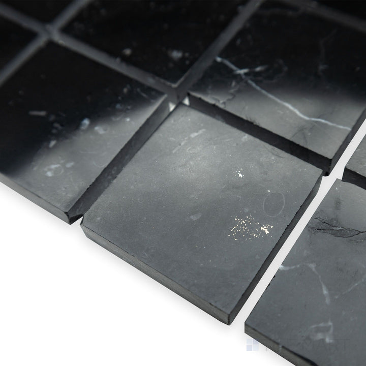 A structured and polished aesthetic is emphasized in this corner view of Negro Marquina Marble 2" square polished mosaic, where its sleek surface enhances the refined grid pattern.