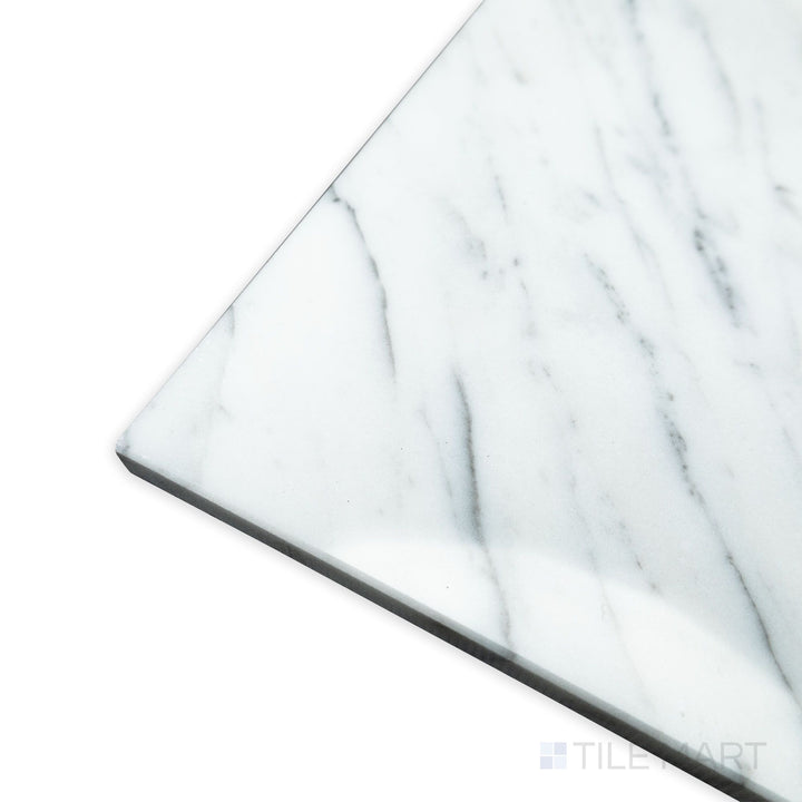 A polished and luminous surface takes center stage in this angled corner shot of Statuary White Marble 12x24 polished tile, reflecting light beautifully.
