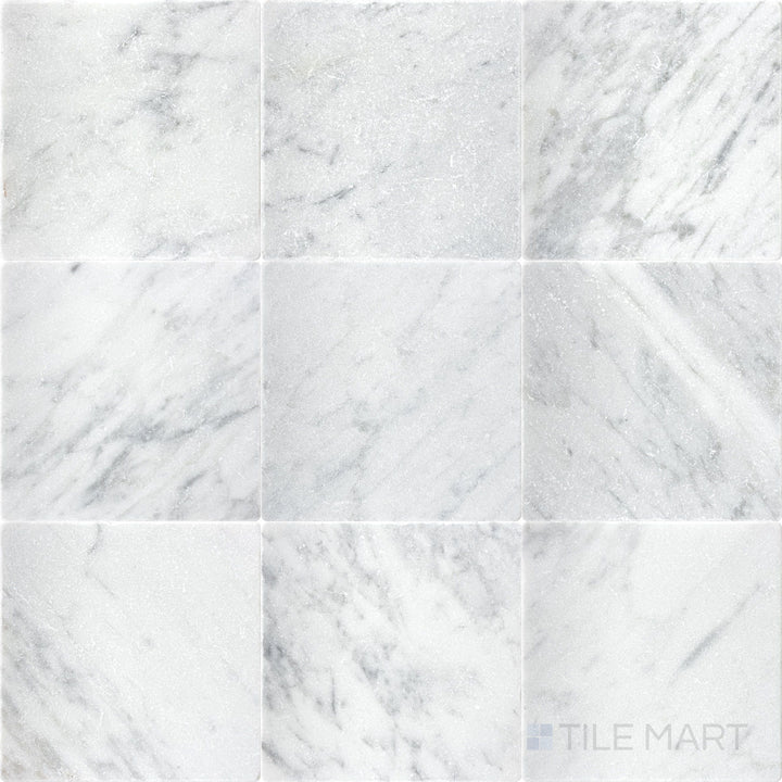 Top-down view of White Carrara Marble 4x4 tumbled tile featuring a textured, rustic marble surface with softened edges for organic wall or floor designs