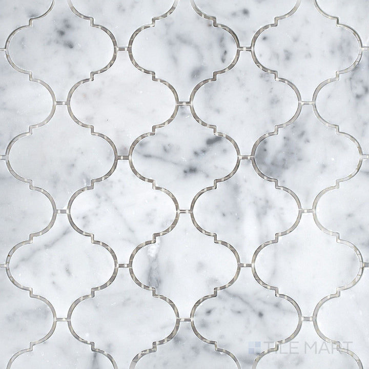 A top-down shot of White Carrara Marble 3-inch arabesque honed mosaic tiles, showcasing a soft matte finish and classic curved pattern for elegant surfaces