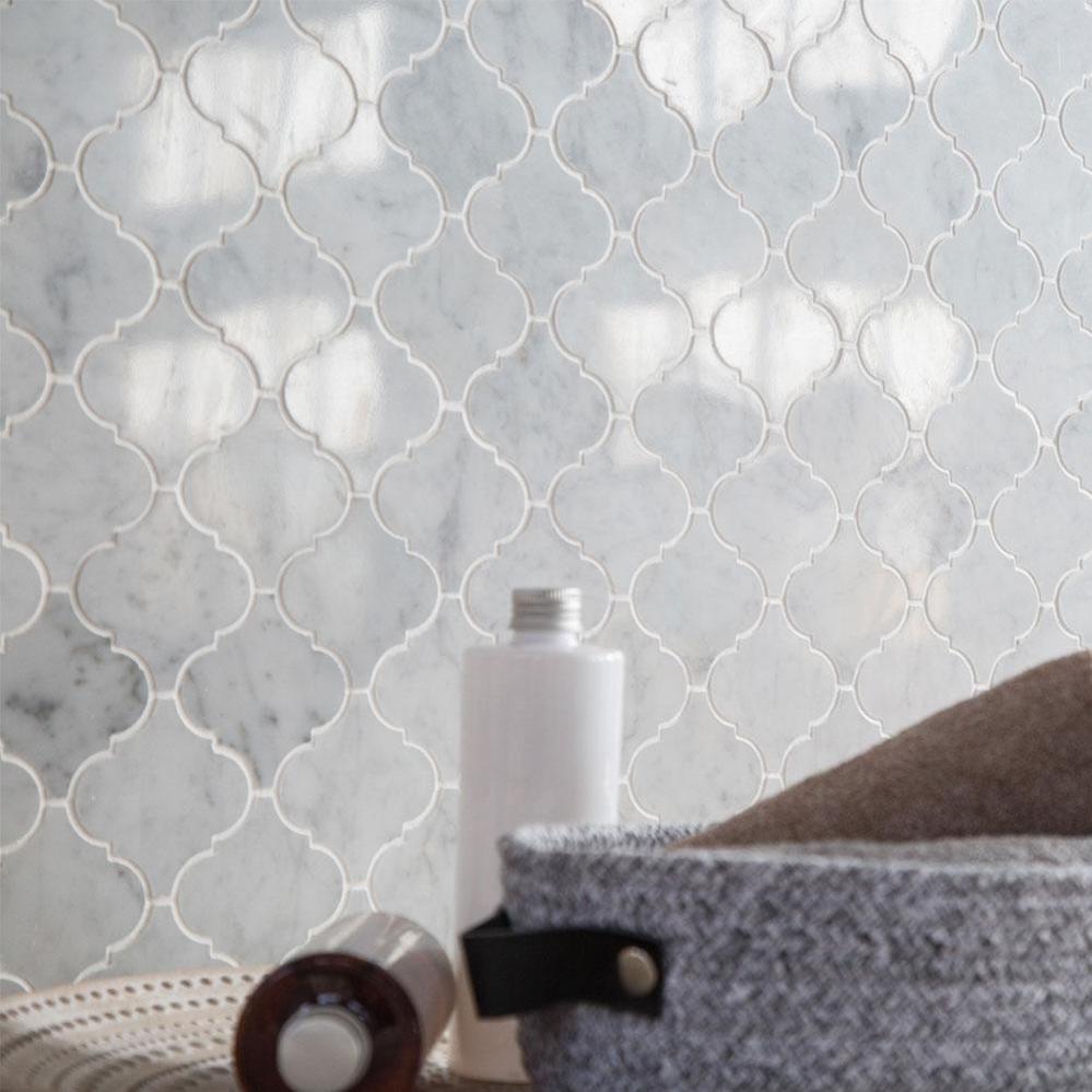 Polished White Carrara marble arabesque mosaic featured in an elegant interior with flowing stone veining