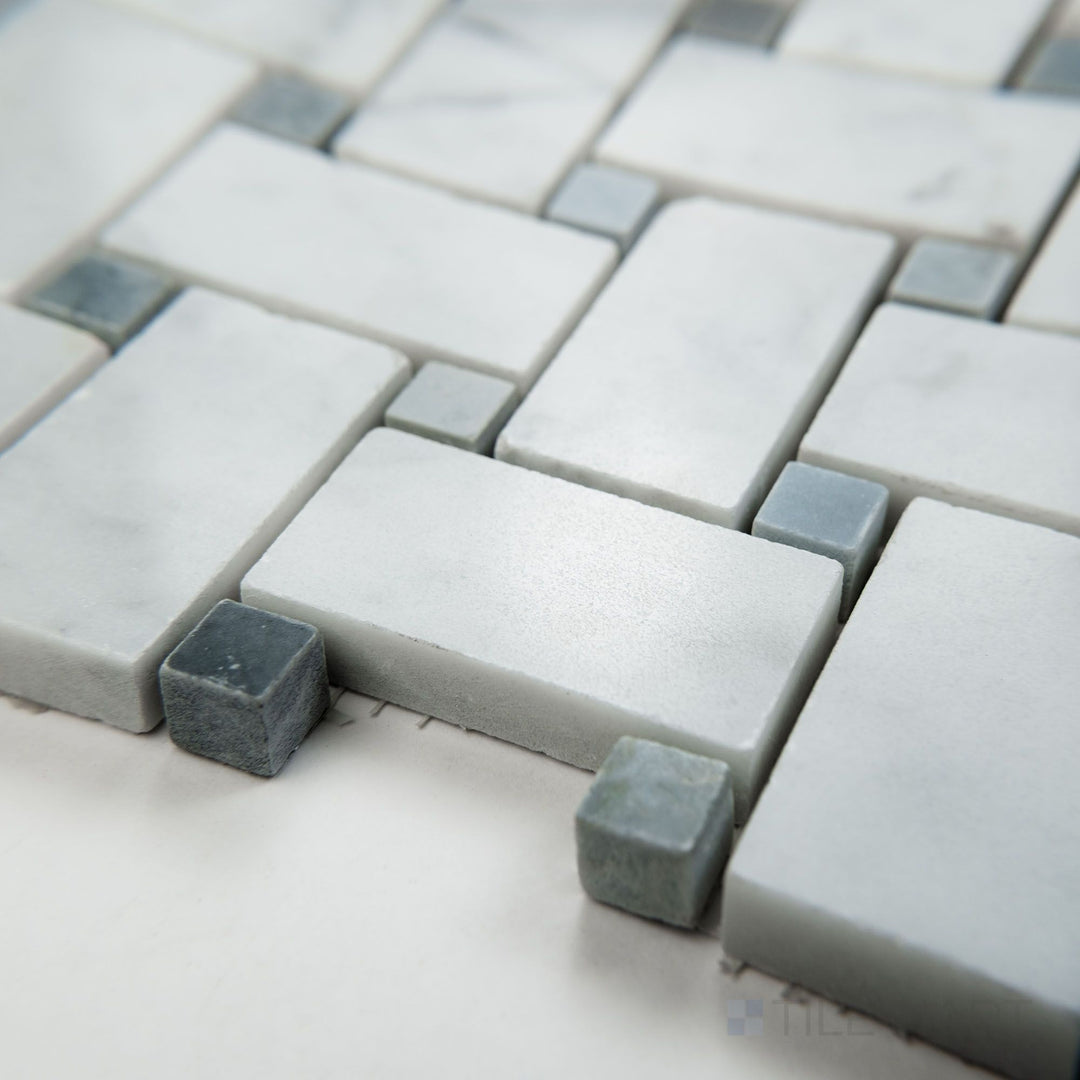 Angled view of White Carrara Marble basketweave mosaic with blue dot in polished finish, highlighting glossy surface and classic white and blue detailing.