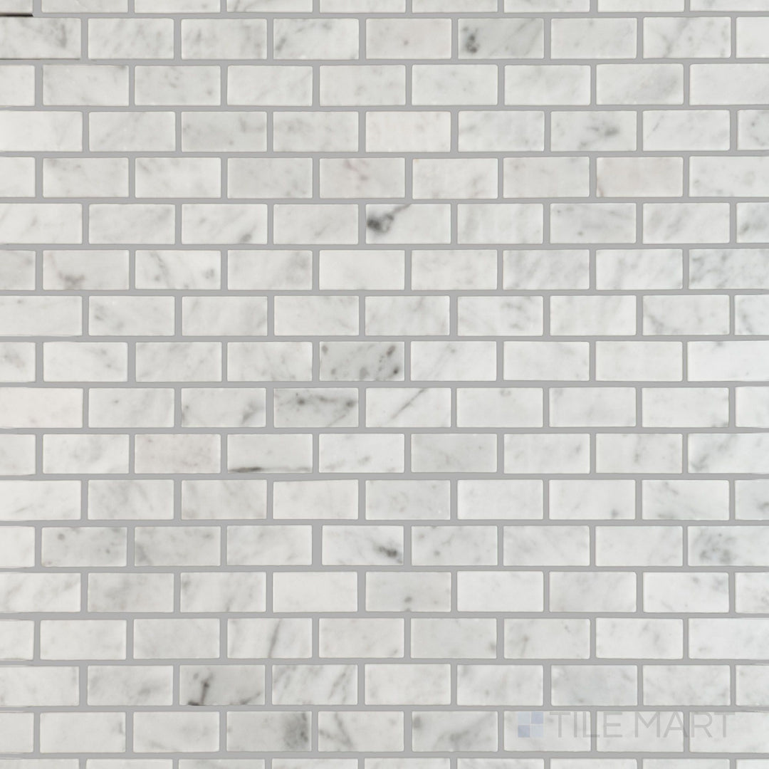 Flat lay showing White Carrara Marble 5/8x1-1 polished brick mosaic tiles, offering a bright reflective surface with a modern linear layout
