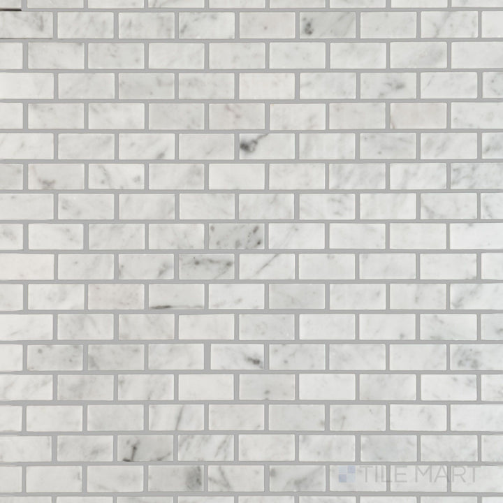 Flat lay showing White Carrara Marble 5/8x1-1 polished brick mosaic tiles, offering a bright reflective surface with a modern linear layout