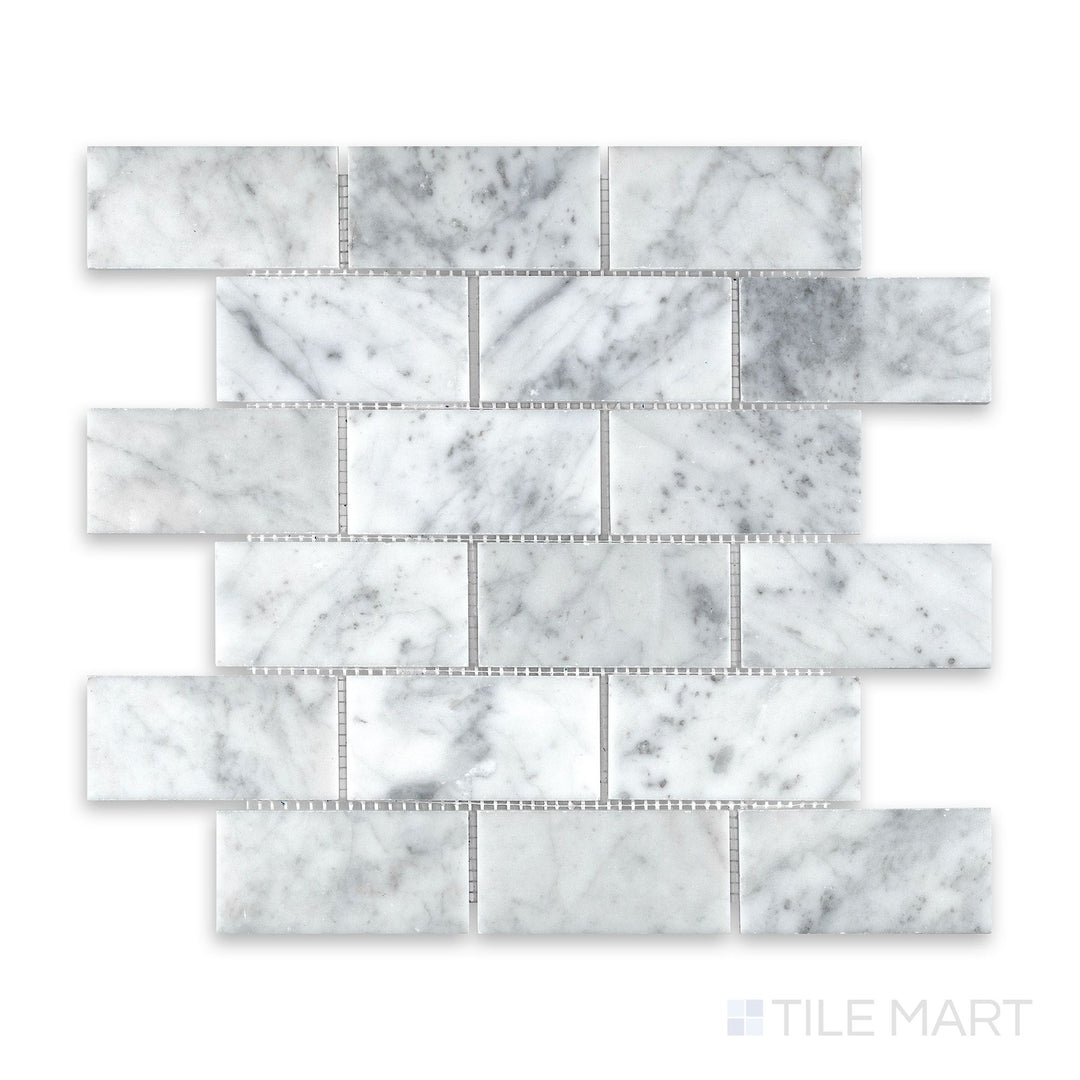 Mosaic display of White Carrara Marble 2x4 brick honed mosaic showing large soft-finish marble tiles in a traditional running bond arrangement