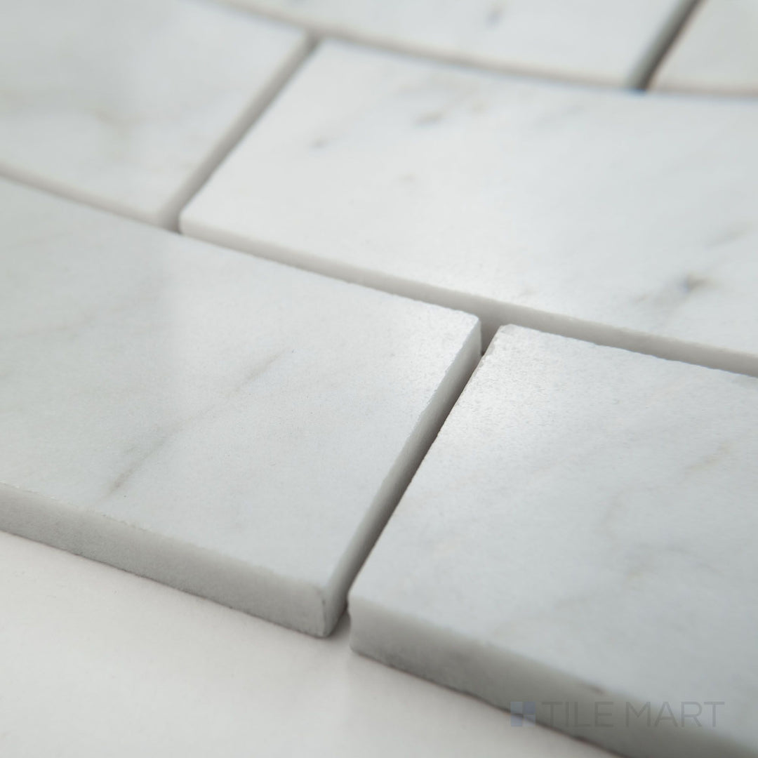 Tile corner display of White Carrara Marble 2x4 brick polished mosaic highlighting larger glossy marble bricks in a classic layout