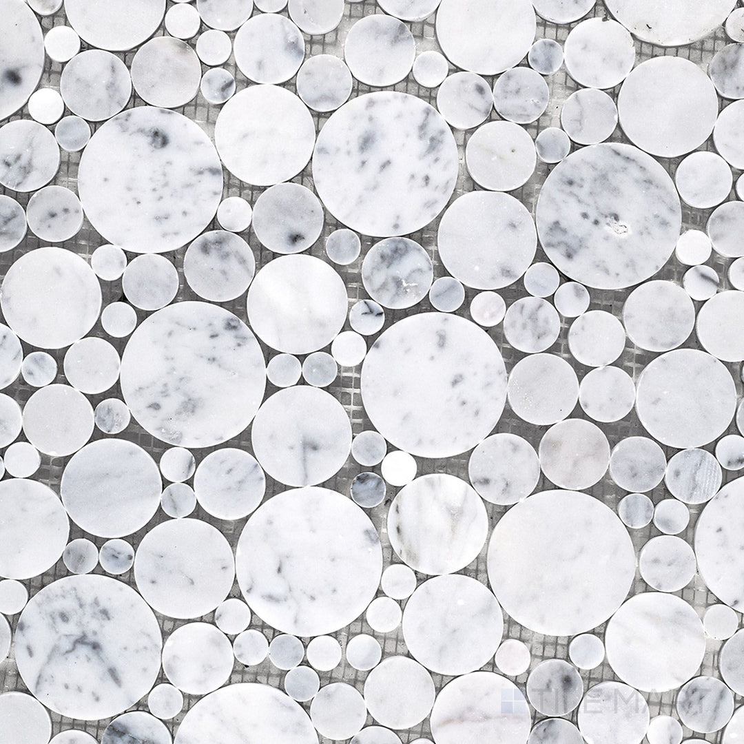 Flat lay of White Carrara Marble bubble honed mosaic tile, showing small circular marble pieces with a soft textured finish for playful surfaces