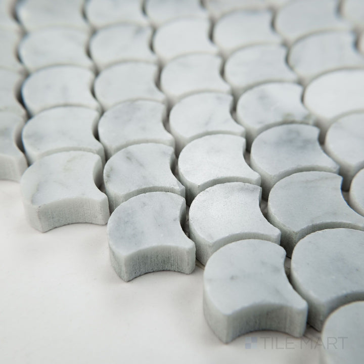 Angled view of White Carrara Marble 1" fan polished mosaic showcasing polished marble fans in a graceful, curving arrangement