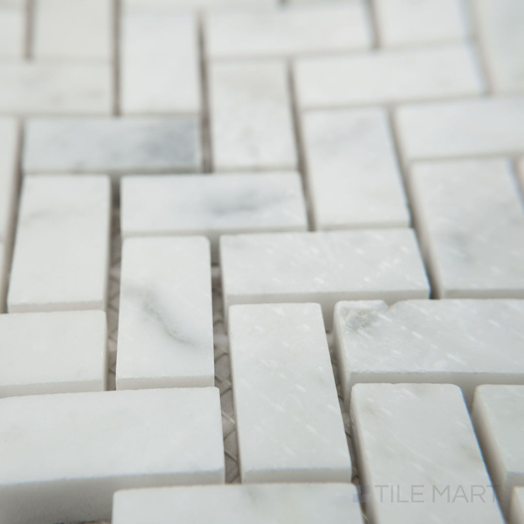 Corner view of White Carrara Marble 5/8x1-1/4 herringbone honed mosaic featuring natural matte marble in an intricate herringbone weave