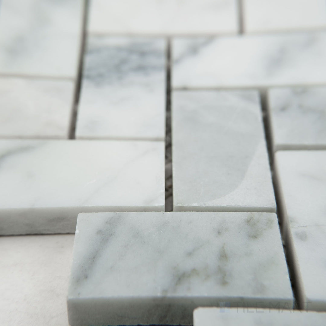 Tile corner display of White Carrara Marble 1x2 herringbone honed mosaic highlighting rectangular matte marble tiles in a herringbone pattern
