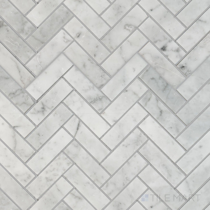 Top-down view of White Carrara Marble 1x3 herringbone honed mosaic featuring soft matte marble tiles arranged in a classic V-shaped pattern