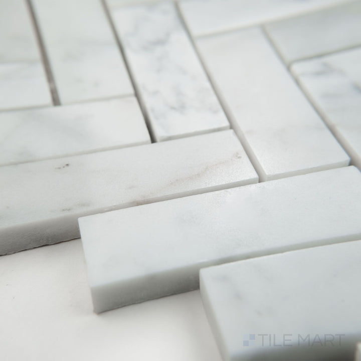 Tile corner display of White Carrara Marble 1x3 herringbone polished mosaic showing glossy marble tiles in a dynamic V pattern