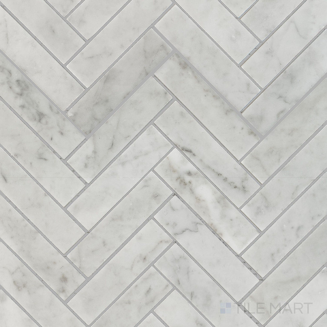Top view of White Carrara Marble 1x4 herringbone honed mosaic, highlighting long rectangular tiles in a soft textured V-shaped arrangement