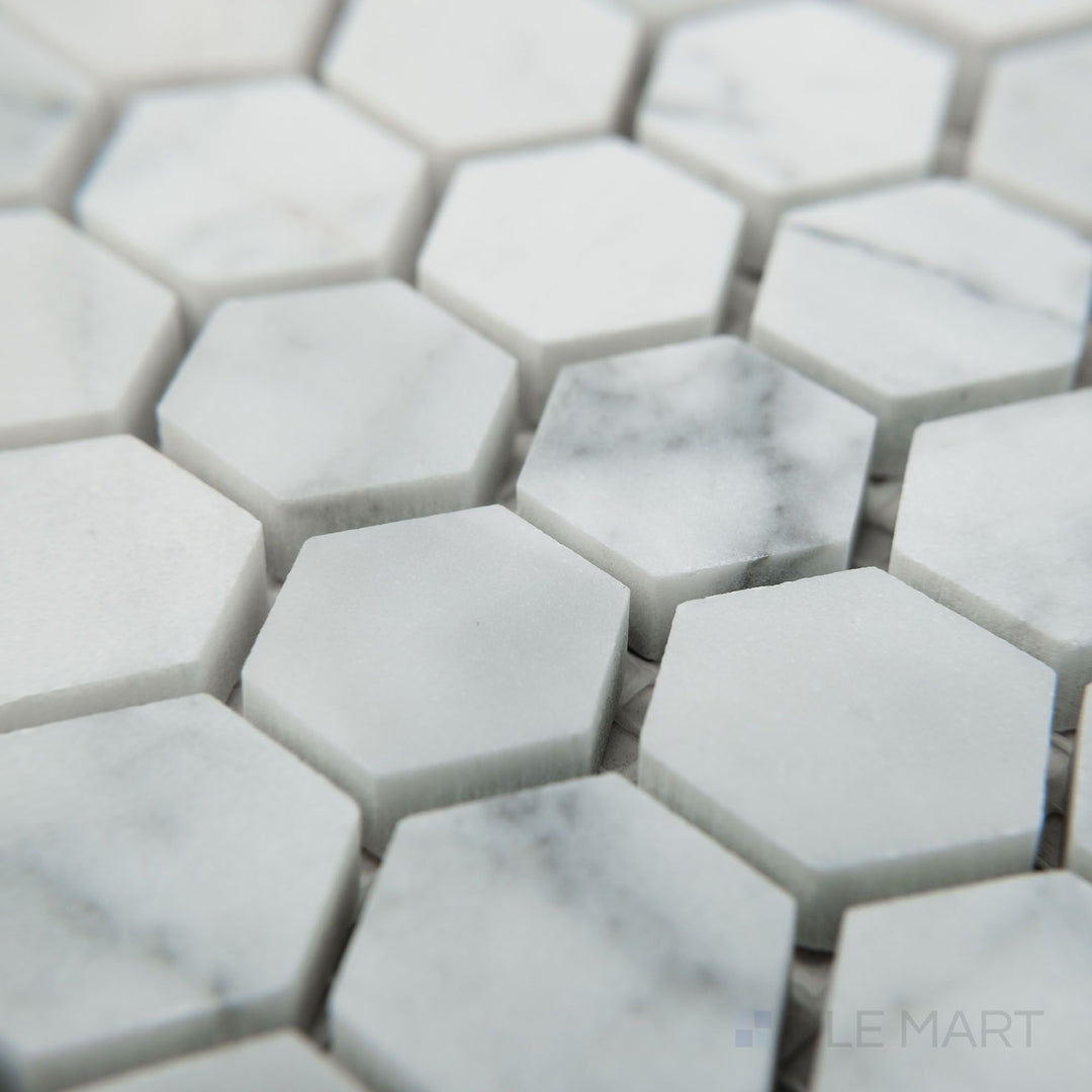 Angled view of White Carrara Marble 1" hexagon honed mosaic displaying small matte marble hexagons in a classic honeycomb layout