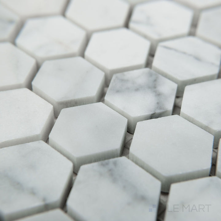 Angled view of White Carrara Marble 1" hexagon honed mosaic displaying small matte marble hexagons in a classic honeycomb layout