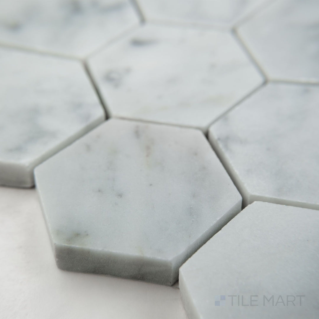 Tile corner display of White Carrara Marble 2" hexagon honed mosaic highlighting larger matte marble hexagons perfect for modern spaces