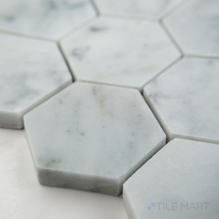Tile corner display of White Carrara Marble 2" hexagon honed mosaic highlighting larger matte marble hexagons perfect for modern spaces