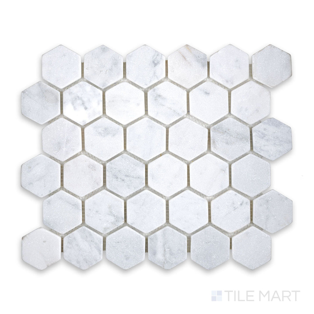 Mosaic display of White Carrara Marble 2" hexagon tumbled mosaic featuring softly textured marble hexagons with a rustic, natural finish