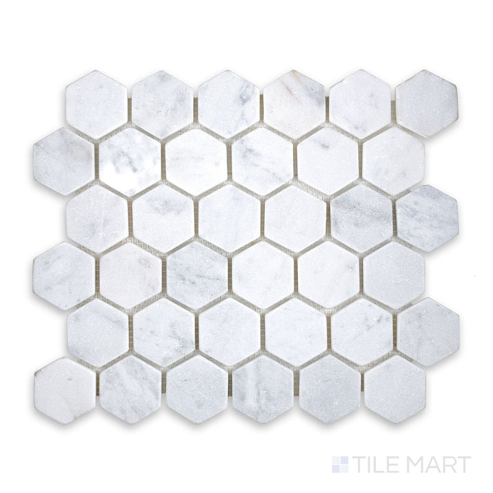 Mosaic display of White Carrara Marble 2" hexagon tumbled mosaic featuring softly textured marble hexagons with a rustic, natural finish