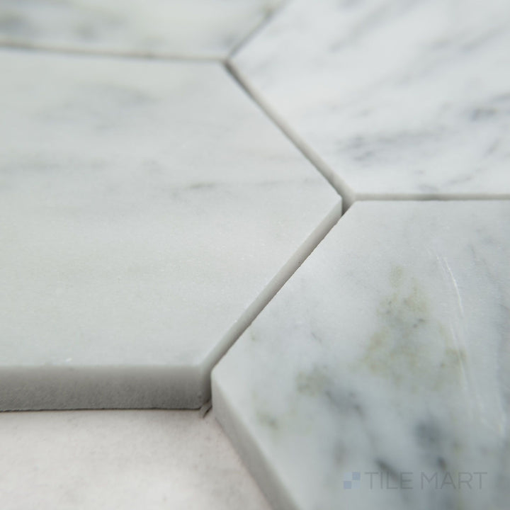 Tile shown from corner angle of White Carrara Marble 3" hexagon honed mosaic revealing larger matte marble hexagons arranged in a classic honeycomb