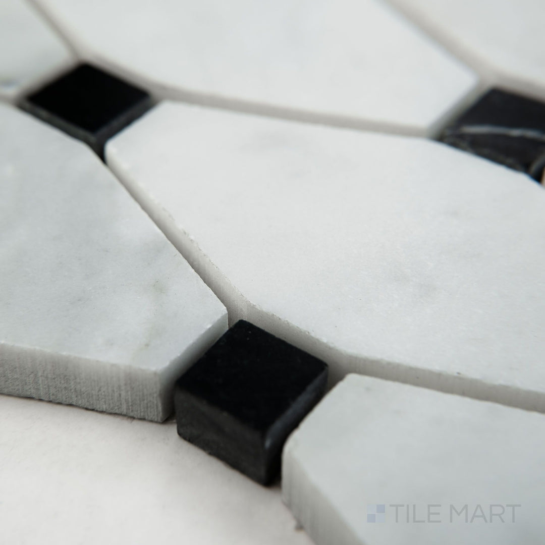 Tile shown from corner angle of White Carrara Marble elongated octagon with black honed mosaic displaying a soft matte finish with bold black details