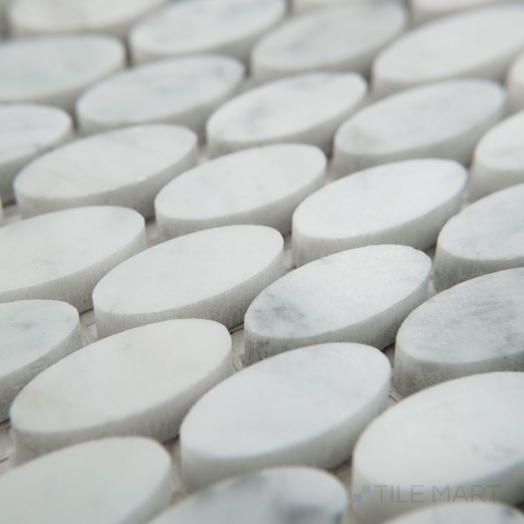 Corner view of White Carrara Marble oval honed mosaic showcasing smooth matte marble ovals arranged in an elegant flowing design