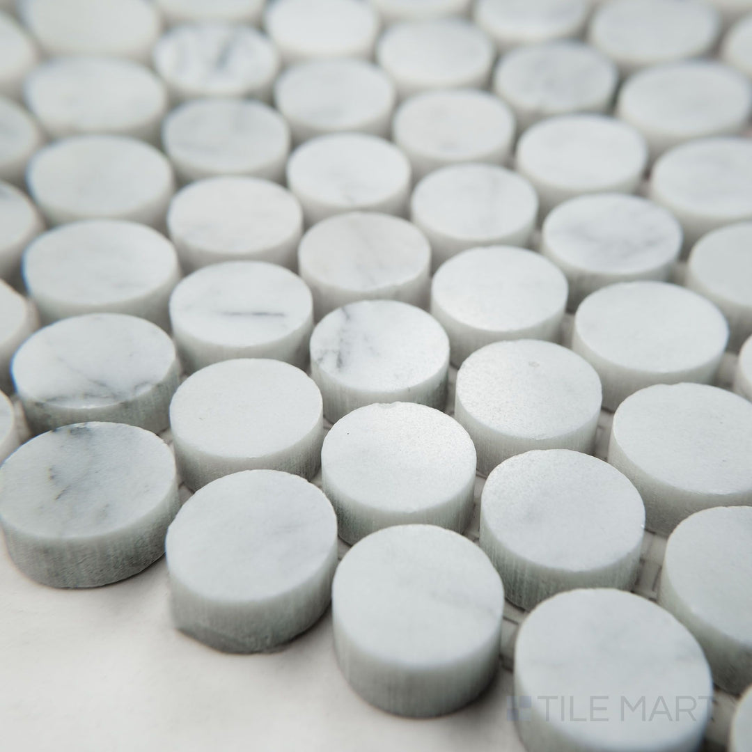 Tile shown from corner angle of White Carrara Marble penny round polished mosaic revealing glossy marble dots arranged in a lively pattern