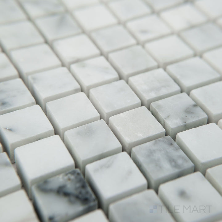 Tile shown from corner angle of White Carrara Marble 5/8" square honed mosaic displaying soft matte marble squares in a classic grid design