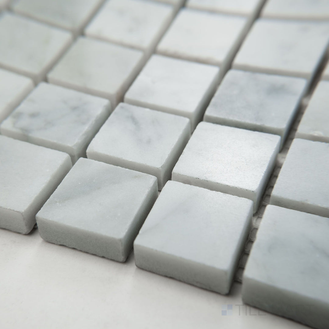 Angled view of White Carrara Marble 1" square polished mosaic showcasing glossy marble squares laid out in a refined and bright pattern