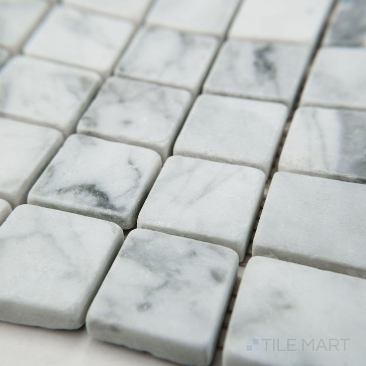 Tile corner display of White Carrara Marble 1" square tumbled mosaic highlighting rustic, textured marble tiles with soft, rounded edges